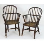 Two mid 19thC Windsor armchairs with bowed stick backs, elm seats and raised on tapering turned legs