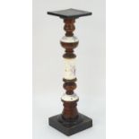 A Continental turned hardwood and ceramic pedestal torchere, the ceramic sections decorated with
