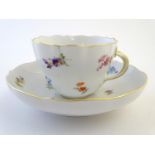 A 19thC Meissen cup and saucer decorated with flowers and gilt highlights. Meissen marks under cup