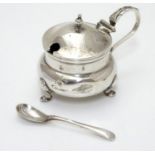 A silver mustard pot with blue glass liner hallmarked Sheffield 1912 maker John Round & Son Ltd (