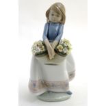 A Lladro figure of a girl with a basket of flowers, May Flowers Girl, model no. 5467. Marked
