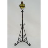 Lighting: a late Victorian oil standard lamp, the brass reservoir supported by a wrought iron