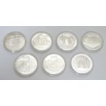 Dominican republic : Seven assorted white metal medallion coins depicting various landmarks /