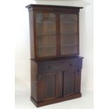 A Victorian mahogany secretaire bookcase, with a moulded cornice above two glazed doors with a