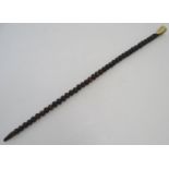 A walking cane / stick composed of threaded nuts / seeds with engraved flower detail, with a horn