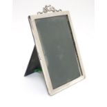 A silver photo frame with ribbon cresting. Hallmarked Birmingham 1908 maker E Mander & Son. 6 1/2"