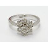 An 18ct gold ring set with 7 diamonds in a daisy cluster setting. the setting approx 3/8" wide. Ring