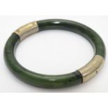 A bracelet of bangle form wit jade coloured hardstone set with gilt metal mounts. Please Note - we