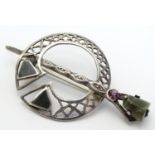 A Scottish silver brooch of penannular form set with hard-stone and amethyst detail. Indistinctly