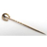 A 9ct gold stick pin surmounted by a horse shoe 1 1/2" long Please Note - we do not make reference