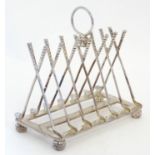 A novelty silver plate 6-slice toast rack the bars formed as golf clubs and standing on four feet
