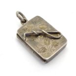A Victorian silver pendant formed locket of squared form with riding whip detail to front. Approx 1"
