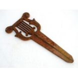 A Victorian cast iron bootscraper, formed as a lyre above a long blade mount, 19" long Please Note -