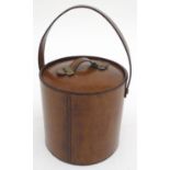 A 20thC ice bucket, the brown leather covering with carrying handle and brass fitments, stainless