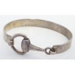 A silver bangle formed bracket with stirrup / horse bit detail. Please Note - we do not make