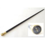 A walking cane with an ebonised shaft, the metal pommel with inset compass. Approx. 34 1/4" Please