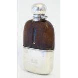 A Victorian hipflask with half leather covering and silver beaker to lower half and with silver
