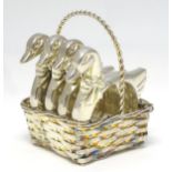 A set of four novelty napkin rings formed as ducks within a basket formed holder. The whole approx 2