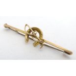A 9ct gold brooch / stock pin with horse shoe and whip decoration. 2" wide Please Note - we do not
