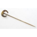 A 15ct gold stick pin / stock pin surmounted by a horseshoe. 3" long Please Note - we do not make