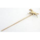 A gold and yellow metal stick pin surmounted by a horse. Marked 10k. Approx 2 3/4" long overall