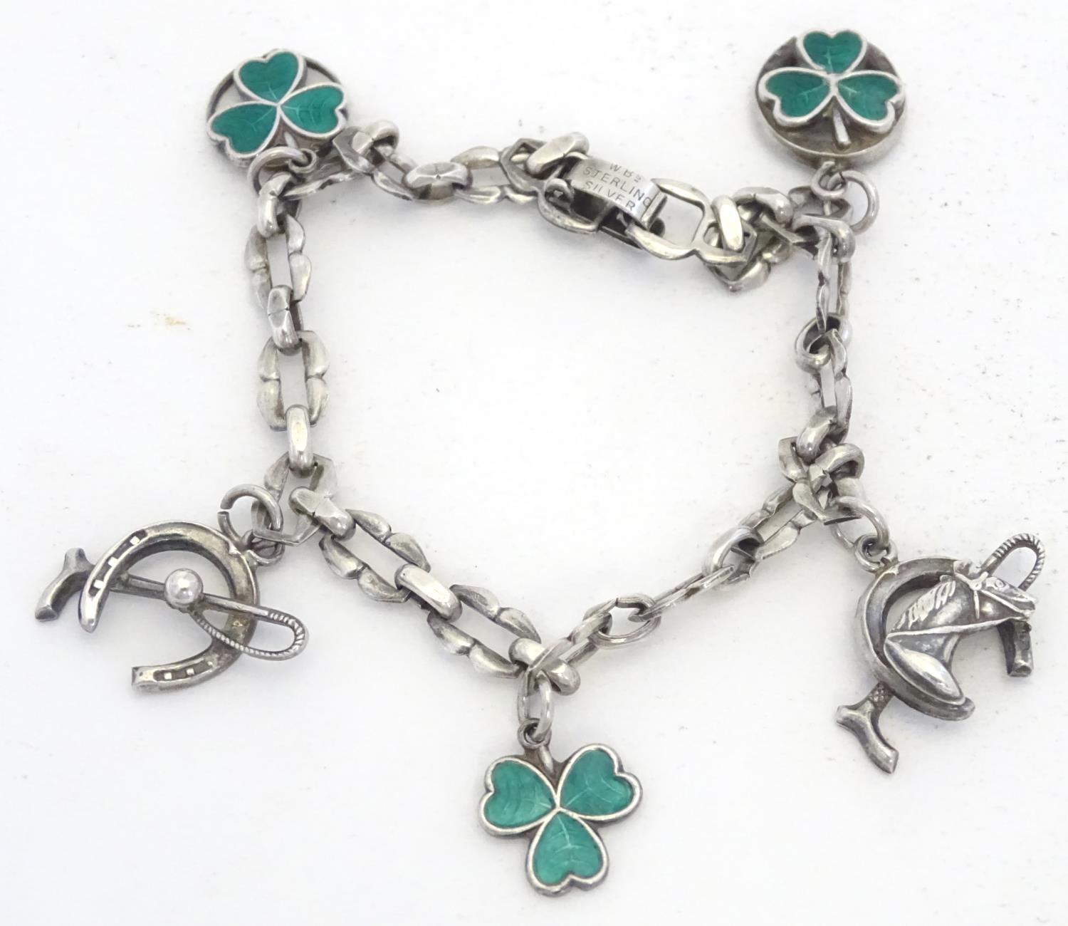 A silver charm bracelet set with various charms including horseshoe, horsehead and horseshoe and