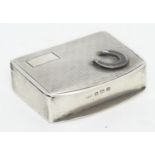 A silver vesta case with engine turned decoration and horseshoe detail to lid. Hallmarked Birmingham