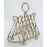 A novelty silver plate 6-slice toast rack the bars formed as cricket bats and stumps, standing on