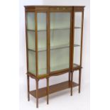 An early / mid 20thC inverted breakfront glazed display cabinet, having a moulded cornice above a