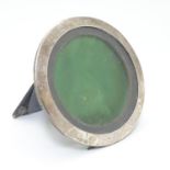A photograph frame of circular form with silver surround hallmarked Birmingham 1917 maker Henry