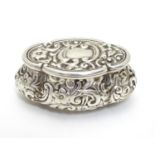 A Victorian small silver box of shaped form with embossed decoration, hinged lid and gilded
