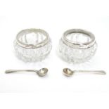 A pair of cut glass salts with silver rims hallmarked London 1902 maker Gibson & Co Ltd together