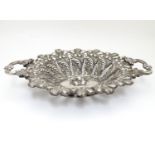 A late 19thC / early 20thC Continental white metal twin handled bowl with embossed fruit and