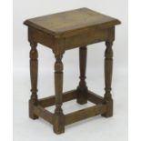 A late 19thC / early 20thC oak joint stool with a moulded surround and standing on four turned