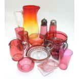 An assortment of cranberry glass items, to include sugar sifters, beakers, bowls, a salt formed as