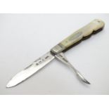 A silver folding fruit knife with integral nut pick blade. With mother of pearl handle.