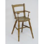A Victorian childs chair with swept arms, turned supports and having an elm seat. Standing on turned