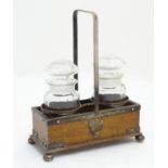A late Victorian double cruet stand, constructed of oak with silver plated banding, ball feet,