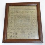 A Victorian needlework sampler decorated with a verse from The Universal Prayer surrounded by