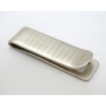 A silver money clip with engraved checked decoration. Approx 2" long Please Note - we do not make