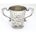 A silver mug of loving cup form with embossed decoration. Hallmarked Newcastle 1760-1768 maker