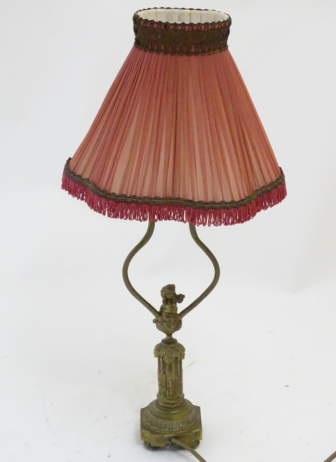 A mid to late 20thC brass table lamp, formed as a Corinthian column surmounted by a putto. 22" - Image 2 of 6