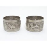 Two white metal napkin rings decorated with elephants, lions, tigers etc. Probably Indian Please