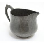 A Hugh Wallis Arts and Crafts hammered pewter cream jug. Stamped with maker's mark under. Approx.