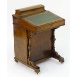 A mid 19thC walnut Davenport with a gold tool leather top and a lidded compartment containing fitted