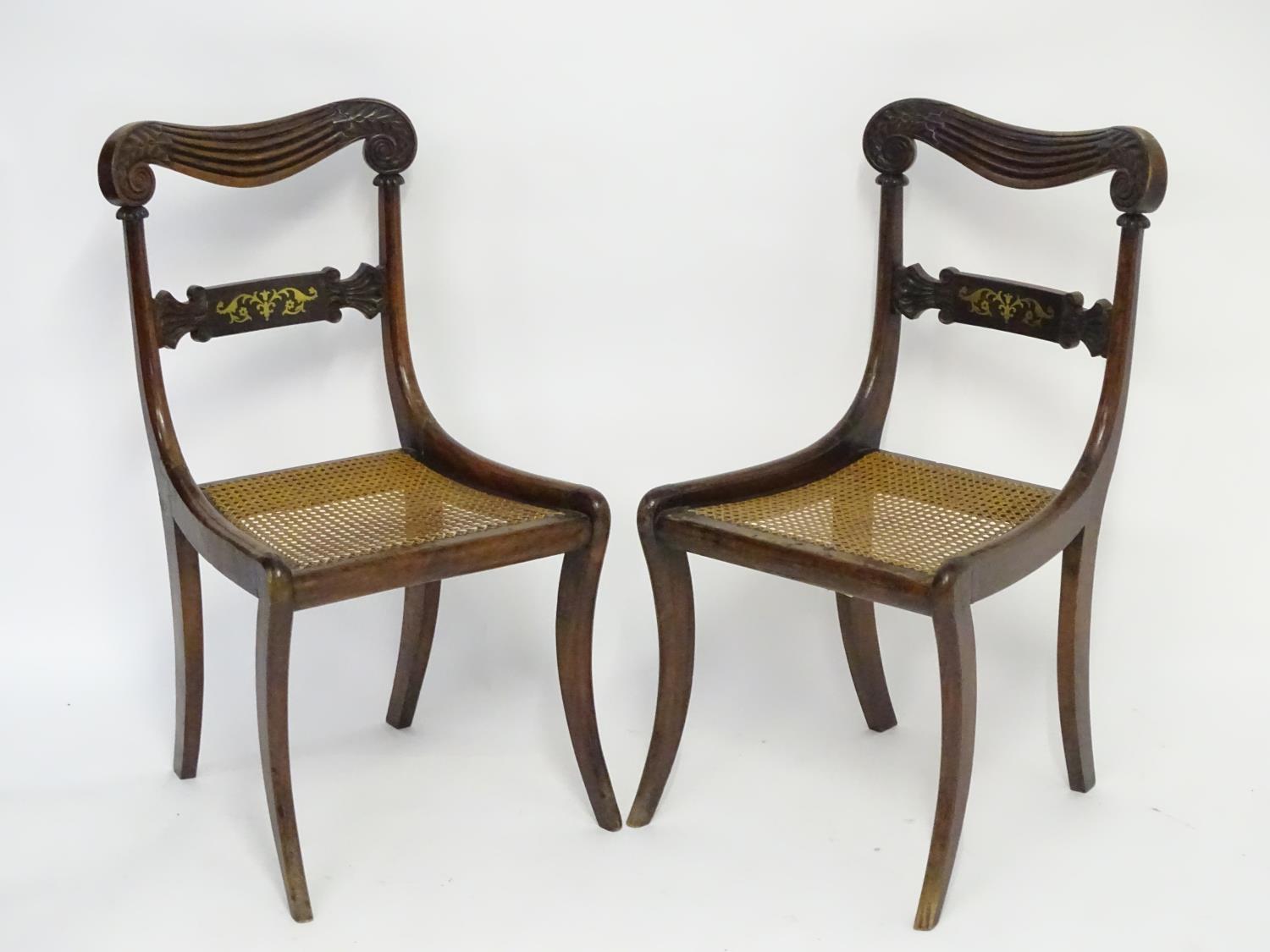 A pair of mahogany 19thC chairs with carved scrolled top rails above brass inlayed mid rails and