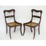 A pair of mahogany 19thC chairs with carved scrolled top rails above brass inlayed mid rails and