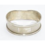 A silver napkin ring with engine turned decoration hallmarked Birmingham 1988 maker B& Co. Please
