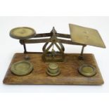 A set of Victorian brass postage / letter scales with five weights on a rectangular wooden base.