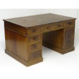 A late 19thC Georgian style partners desk with an inset leather top above two banks of drawers and